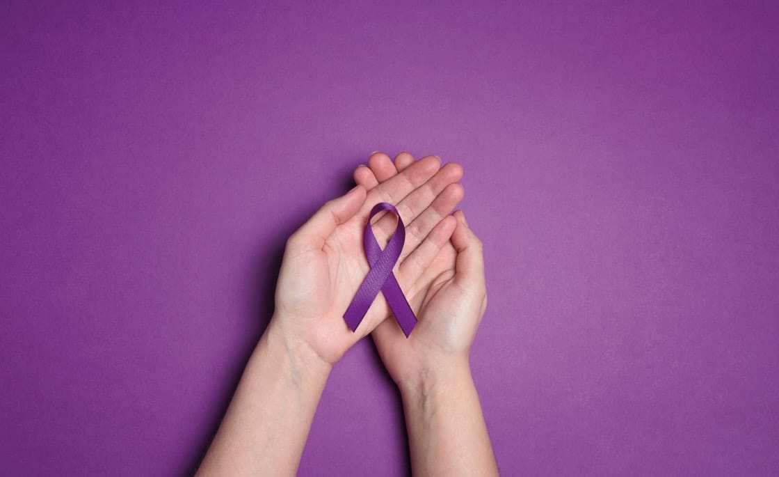 lazo morado y manos de mujer sujetandolo
