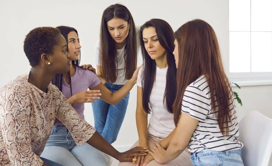 Mujeres sin hogar apoyándose