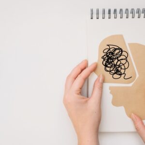 mano haciendo collage con un cerebro en papel