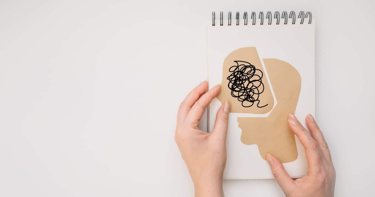 mano haciendo collage con un cerebro en papel